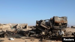 A man sits beside the wreckage of burnt military supply vehicles used by suspected Islamic State fighters in the Cal Miskaad mountain range in Bari, east of the Gulf of Aden in the city of Bosaso, Puntland region, Somalia, Jan. 25, 2025.