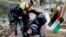 A wounded Palestinian photojournalist is evacuated during an anti-Israel protest against the U.S. President Donald Trump&#39;s Middle East peace plan, in Hebron in the Israeli-occupied West Bank.