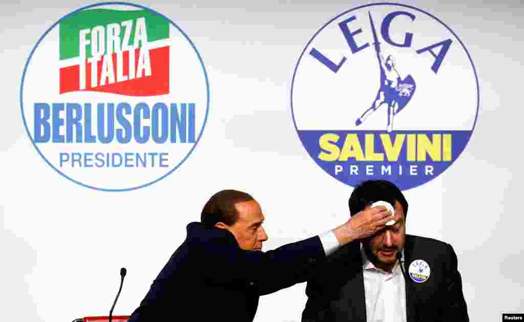 Forza Italia leader Silvio Berlusconi wipes the sweat off Northern League leader Matteo Salvini during a meeting in Rome, Italy.