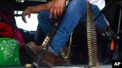 A member of the so-called self-defense group known as Pueblos Unidos sits with his ammunition during a rally in Nuevo Urecho, in the Mexican western state of Michoacan, Nov. 27, 2021.