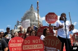 In this July 22, 2015, file photo, Tribal councilman Wendsler Nosie, Sr. speaks with Apache activists in a rally to save Oak Flat, land near Superior, Ariz., sacred to Western Apache tribes, in front of the U.S. Capitol in Washington, D.C.