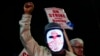 A Boeing worker wears a mask with a digital 'strike' sign as employees picket after union members voted overwhelmingly to reject a contract offer and go on strike Sept. 13, 2024, outside the company's factory in Renton, Wash. 