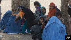 Afghan refugee families sit outside the government registration office preparing to leave for their homeland, in Peshawar, Pakistan, March 14, 2017.