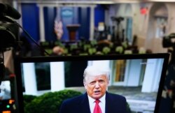 FILE - U.S. President Donald Trump is seen on TV from a video message released on Twitter addressing rioters at the US Capitol, in the Brady Briefing Room at the White House, Jan. 6, 2020.