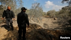 Palestinian policemen loyal to Hamas inspect the scene of an Israeli air strike in the northern Gaza Strip Oct. 28, 2013. 