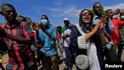 Sudanese protesters march in a demonstration to mark the anniversary of a transitional power-sharing deal with demands for quicker political reforms in Khartoum, Sudan, Aug. 17, 2020.