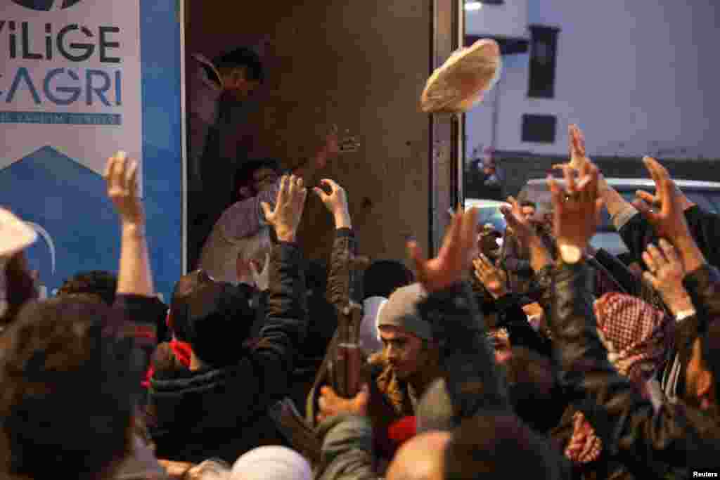 People gather to receive flatbread after rebels seized the capital and ousted Syrian President Bashar al-Assad, in Damascus. REUTERS/Mohamed Azakir