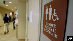 FILE- A sign marks the entrance to a gender-neutral restroom at the University of Vermont in Burlington, Vermont.