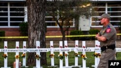 ARHIVA - Policajac prolazi pored memorijala za žrtve masovnog ubistva u osnovnoj školi u Uvaldeu, u Teksasu (Foto: CHANDAN KHANNA / AFP)