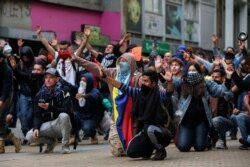 Demonstrators gesture during a protest on the second day of a national strike, in Bogota, Colombia, Nov. 22, 2019.
