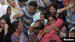 Family members mourn the death of a relative, who was killed in a blast outside a public park on Sunday, during funeral in Lahore, Pakistan, March 28, 2016.