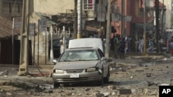 A body is seen at the site of a bomb explosion at a road in Kaduna, Nigeria, April 8, 2012.