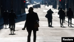 People are seen silhouetted while they walk at Via del Corso street, as Italy goes back to lockdown as part of efforts put in place to curb the spread of the coronavirus disease (COVID-19), in Rome, Italy, Dec. 31, 2020.