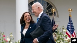 ARCHIVO - La vicepresidenta Kamala Harris y el presidente Joe Biden sonríen mientras caminan después de un discurso sobre la actualización de la política del uso de mascarillas para prevenir el contagio por COVID-19, el 13 de mayo de 2021 en Washington. 