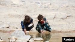 FILE - Displaced Yemeni girls are seen near a watercourse at a refugee camp located between Marib and Sanaa, Yemen, March 29, 2018.