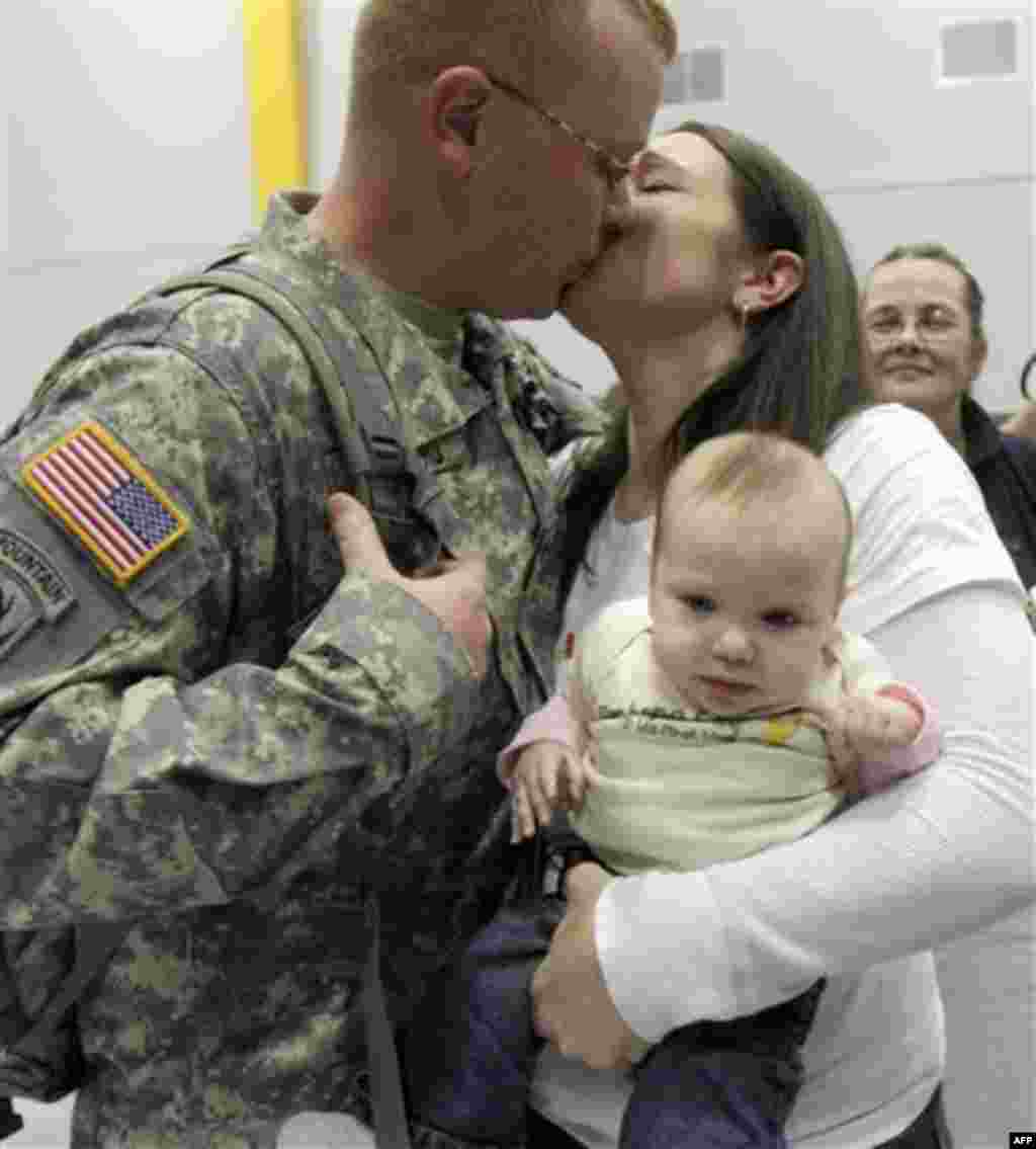 Spc. Ryan Richard of Milton, Vt., gets a kiss from his wife, Amanda who holds daughter Mckenzie during a homecoming for Vermont National Guard troops on, Monday, Nov. 22, 2010 in South Burlington, Vt. It was Richard's first look at his daughter Mckenzie, 