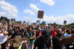 Striking screenwriters and actors hold signs at a rally in Chicago, Thursday, July 20, 2023, as the labor dispute that has halted Hollywood spreads to more cities. (AP Photo/Teresa Crawford)