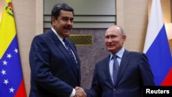 FILE PHOTO: Russian President Vladimir Putin, right, shakes hands with his Venezuelan counterpart Nicolas Maduro during a meeting at the Novo-Ogaryovo state residence outside Moscow, Russia Dec. 5, 2018. 