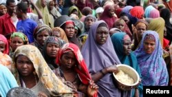  Internally displaced Somali women wait for food at a camp in the capital Mogadishu, July 2011.