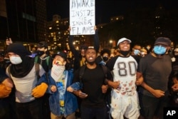 Activists march to the Brooklyn Bridge on Sunday, May 31, 2020, in New York. Demonstrators took to the streets of New York City to protest the death of George Floyd, who died May 25 after he was pinned at the neck by a Minneapolis police officer.