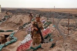 FILE - Iraqi security forces secure the Iraq-Syria border around Rabiaa border crossing, Iraq, Oct. 16, 2019. Iraq's defense minister said members of the Islamic State group were able to flee northern Syria and cross into Iraq.