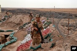 FILE - Iraqi security forces secure the Iraq-Syria border around Rabiaa border crossing, Iraq, Oct. 16, 2019. Iraq's defense minister said members of the Islamic State group were able to flee northern Syria and cross into Iraq.
