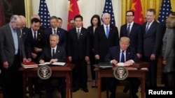 El presidente Donald Trump junto al viceprimer ministro y principal negociador por China, Liu He, firman la primera fase del acuerdo comercial en Washington, el miércoles 15 de enero de 2020.