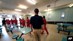 Detainees leave the cafeteria under the watch of guards during a media tour at the Winn Correctional Center in Winnfield, La., Sept. 26, 2019. 