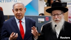 PM Israel Benjamin Netanyahu (kiri) dan Menteri Kesehatan Yaakov Litzman di Kiryat Malachi, Israel, 1 Maret 2020. 