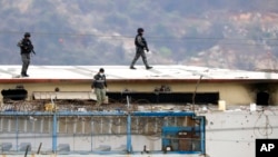 Body of a prisoner appears surrounded by police on roof of Litoral penitentiary after riots broke out inside jail in Guayaquil, Ecuador, Nov. 13, 2021.