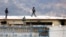 Body of a prisoner appears surrounded by police on roof of Litoral penitentiary after riots broke out inside jail in Guayaquil, Ecuador, Nov. 13, 2021.