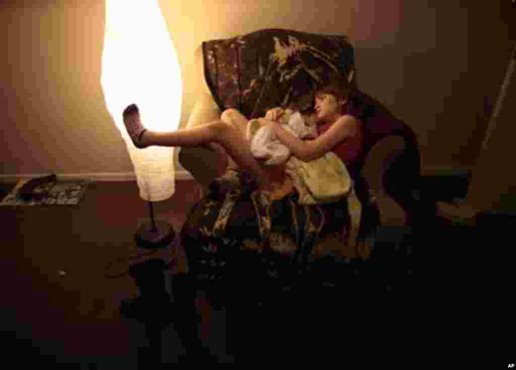 Lilly Earp, 8, hugs her five-week-old sister Emily in their apartment at Hope Gardens Family Center, a shelter for homeless women and children, run by Union Rescue Mission on 77 acres (0.31 square km) of countryside away from Skid Row, on the outskirts of