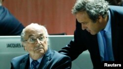 Michele Platini (de pie) y Joseph Blatter, fueron suspendidos provisionalmente por la FIFA.