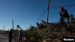 Trabajadores reparan líneas eléctricas dañadas durante el paso del huracán Rafael en Caimito, Cuba, el 18 de noviembre de 2024