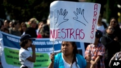 A protester carries a sign reading "Our arms," as members of a dissident teachers union participate in one of four coordinated marches in Mexico City, July 6, 2016.