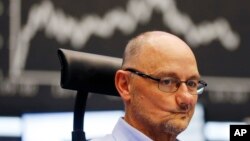 A trader grimaces as he watches his screens at the stock market in Frankfurt, Germany, July 6, 2015.