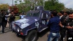 Pakistani journalists surround an armored vehicle carrying Rao Anwar, a police officer accused of killing a 27-year-old man in an allegedly "stage-managed" shootout in the port city of Karachi that sparked outrage on the part of Pakistan's tribal communities, at the Supreme Court in Islamabad, Pakistan, March 21, 2018. 