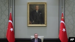 Turkey's President Recep Tayyip Erdogan, backdropped by a painting depicting modern Turkey's founder Mustafa Kemal Ataturk, chairs his government's cabinet in Ankara, Turkey, April 26, 2021.