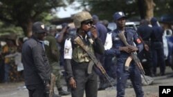 Ivory Coast policemen stand guard during a youth rally in Abidjan, Ivory Coast, 20 Dec 2010