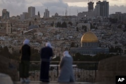 FILE— Muslim women visit the Mount of Olives, overlooking the Dome of the Rock at the Al Aqsa Mosque compound in the Old City of Jerusalem, March 7, 2024.