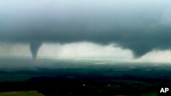 Esta imagen tomada de un video provisto por KWTV-KOTV muestra dos nubes en forma de cono en Crescent, Oklahoma, el lunes 20 de enero de 2019.