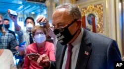 El líder de la mayoría en el Senado de EE. UU., Chuck Schumer, sale de una reunión demócrata del Senado agitando el puño en el Capitolio en Washington, el 6 de octubre de 2021.
