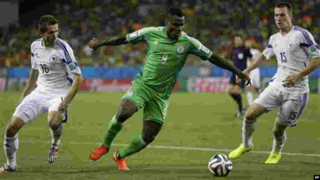 Nigeria's Emmanuel Emenike, centre, is challenged by Bosnia's Senad Lulic.