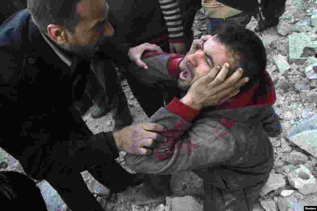 A man reacts after what activists said was an air raid by forces loyal to Syrian President Bashar Al-Assad in Aleppo&#39;s al-Marja district. More than 300 people have been killed in a week of air raids on the northern city of Aleppo and nearby towns, a monitoring group said.