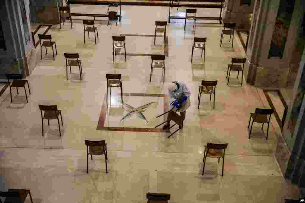 A woman cleans SS. Quirico and Giulitta Church in Giussano, Italy. Religious centers in Italy are preparing to reopen to the public for masses after Italy partly lifted restrictions following a two-month lockdown in an effort to stop the spread of COVID-19.