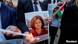 صحافی شیریں ابو عاقلہ کی یاد میں بیت الحم میں منعقدہ ایک تقریب میں لوگ ان کی تصاویر اٹھائے ہوئے ہیں۔(فائل)