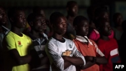 Ces personnes regardent le documentaire "Number 12" par le journaliste d'investigation Anas Aremeyaw Anas au sujet de l'ancien président de la Ghanian Football Association (GFA), Kwesi Nyantakyi, à Accra, le 10 juin 2018 (AFP PHOTO / CRISTINA ALDEHUELA).