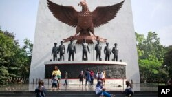 Para pengunjung berfoto di Monumen Pancasila Sakti, Jakarta, 15 Oktober 2017. (Foto: AP)