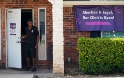 FILE - A security guard opens the door to the Whole Women's Health Clinic in Fort Worth, Texas, Sept. 1, 2021.