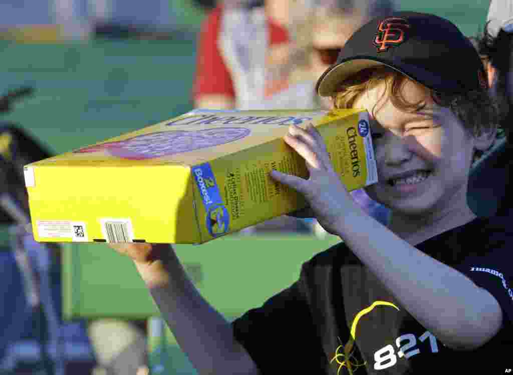 Griffin O&#39;Roak watches the rising sun with his homemade eclipse viewer at a gathering of eclipse viewers in Salem, Ore., Monday, Aug. 21, 2017. (AP Photo/Don Ryan)